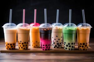 Plastic cups of different tasty bubble tea. Row of fresh boba bubble tea glasses. photo