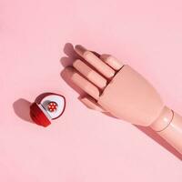A mannequin hand and a heart shape box with the ring inside, romantic love concept. photo