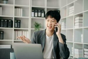 Portrait of young man sitting at his desk in the office photo