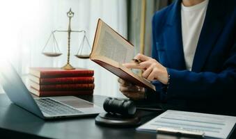 mujer abogado leyendo legal libro con mazo en mesa en oficina. justicia y ley ,abogado concepto. foto