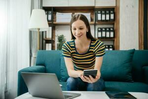 Caucasian businesswoman working in the office with working notepad, tablet and laptop documents on sofa in home office photo