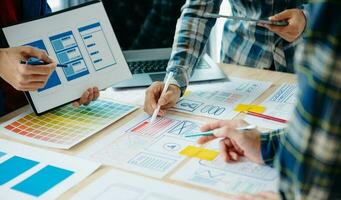 UX developer and ui designer brainstorming about mobile app interface wireframe design with customer breif and color code at modern office. photo