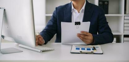 Business man working at office with laptop and documents on his desk new start up project. Finance task. photo