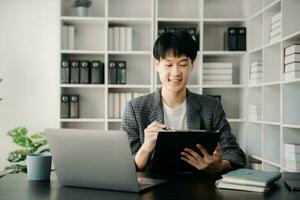 Portrait of young man sitting at his desk in the office photo