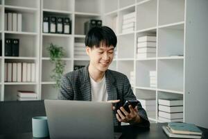 Portrait of young man sitting at his desk in the office photo