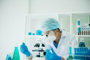 Scientist mixing chemical liquids in the chemistry lab. Researcher working in the chemical laboratory photo