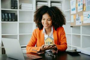 African woman working with House model real estate agent and customer discussing for contract to buy house, insurance or loan real estate consult concerning mortgage loan offer photo