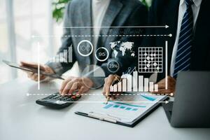 Concept of digital diagram,graph interfaces,virtual icon. Team of business analysts discussing the business strategy in contemporary using on smartphone and tablet with startup project photo