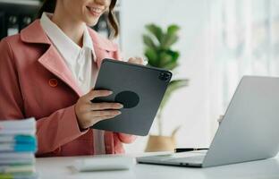 Woman hand using smart phone, tablet payments and holding credit card online shopping, omni channel, digital tablet docking keyboard computer at office in sun light photo