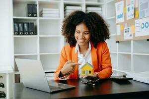 africano mujer trabajando con casa modelo real inmuebles agente y cliente que se discute para contrato a comprar casa, seguro o préstamo real inmuebles consultar sobre hipoteca préstamo oferta foto