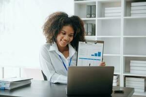 Business woman using tablet and laptop for doing math finance on an office desk, tax, report, accounting, statistics, and analytical research concept in office photo