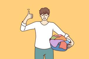 Man householder with laundry in basin shows thumbs up recommending quality laundry detergent. Guy getting ready to load textiles into washing machine setting positive example for peers vector