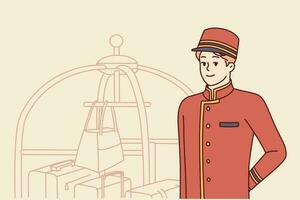 Bellboy works at hotel standing near cart with suitcases and bags of guests. Young man makes career as bellboy waiting for new clients who need help and are ready to thank bellhop with tip vector