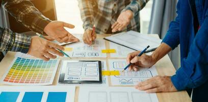 UX developer and ui designer brainstorming about mobile app interface wireframe design with customer breif and color code at modern office. photo