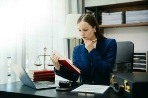 .femenino juez en un sala de justicia en de madera mesa y consejero o masculino abogado trabajando en oficina. justicia y ley concepto foto