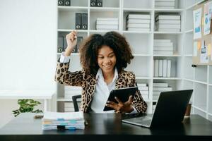 Business woman using tablet and laptop for doing math finance on an office desk, tax, report, accounting, statistics, and analytical research concept in office photo