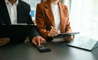Business documents on office table with smart phone and calculator digital tablet and graph photo