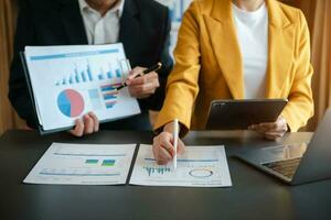 Business documents on office table with smart phone and calculator digital tablet and graph photo