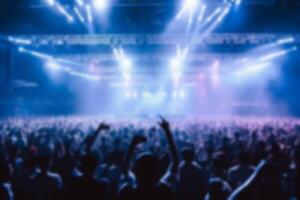 blurred crowd audience watching and listening live show on stage  in concert hall. group of people together in stadium with fantastic lighting effect background. generative AI photo