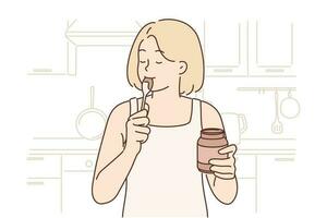 Happy woman stands in kitchen with jar of chocolate paste or peanut butter and licks spoon satisfying hunger with junk food. Positive girl eats high-calorie peanut butter after long diet vector