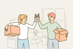 Happy married couple moving into new house and giving each other high five standing with boxes in hands. Man and woman rejoice in moving and renting good property or profitable mortgage vector