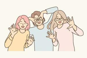 Three happy girls of friend have fun making funny faces and putting fingers to faces instead of glasses. Positive women dressed in casual clothes pose together for commemorative photo vector