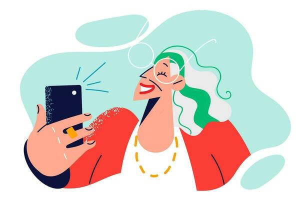 Elderly woman takes selfie on mobile phone and smiling poses for picture for social network. Fashionable elderly woman with smartphone makes video call or records vlog for internet site