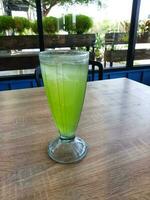 A glass of iced melon lemonade. Fresh orange juice with sweet melon syrup. photo