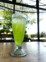 A glass of iced melon lemonade. Fresh orange juice with sweet melon syrup. photo