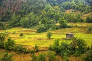 Alone old wooden house on a hill in a mountain. photo