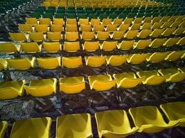 sillas de plástico rojas vacías en las gradas del estadio o anfiteatro. muchos asientos vacíos para los espectadores en las gradas. foto