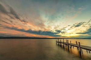 Idyllic sunset at the seashore with a wooden pier. Time for relaxing photo