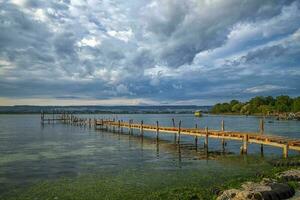 Beauty and calm sunset on the lake with a wooden pier photo