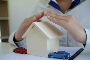 Concept of car insurance with Protection of a car. toy car and hand Business concept photo