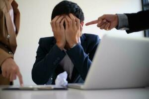 Bullying with an out of control boss shouting to a stressed employee. Anger issues and stress concept. photo