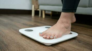 feet standing on electronic scales for weight control. Measurement instrument in kilogram for a diet control photo