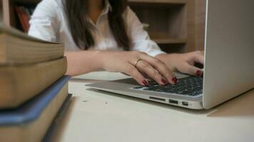 Working by using a laptop computer on wooden table. Hands typing on a keyboard. photo