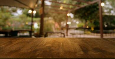 image of wooden table in front of abstract blurred background of outdoor garden lights. can be used for display or montage your products.Mock up for display of product. photo