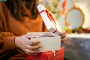 Happy asian woman open Christmas box and surprises. preparing surprise for xmas present in holiday photo