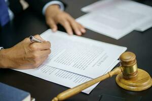 El asesor legal presenta al cliente un contrato firmado con mazo y ley legal. concepto de justicia y abogado foto