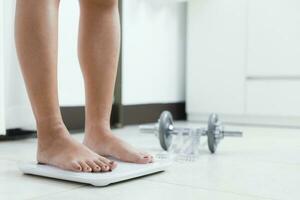 feet standing on electronic scales for weight control. Measurement instrument in kilogram for a diet control. photo