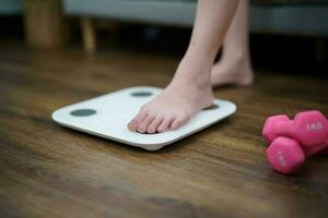 Fat diet and scale feet standing on electronic scales for weight control. Measurement instrument in kilogram for a diet control photo