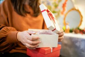 Happy asian woman open Christmas box and surprises. preparing surprise for xmas present in holiday photo