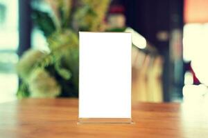 Mock up Menu frame standing on wood table in Bar restaurant cafe. space for text photo