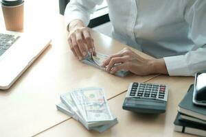 Businesswoman analyzing investment charts and pressing calculator buttons over documents. Accounting Concept. photo