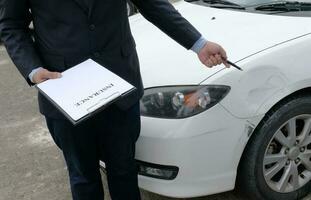 pérdida ajustador seguro agente inspeccionando dañado coche. foto