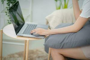 Working by using a laptop computer on wooden table. Hands typing on a keyboard.technology e-commerce concept photo