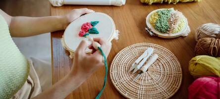 Punch needle. Asian Woman making handmade Hobby knitting in studio workshop. designer workplace Handmade craft project DIY embroidery concept. photo