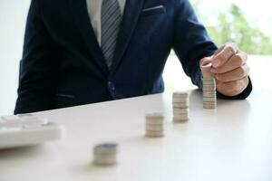 Accountant verify the business and saving money stacking gold coins with calculator. Accountancy Concept photo