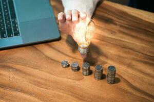 saving coins idea with light bulb for investment Concept idea and innovation. photo